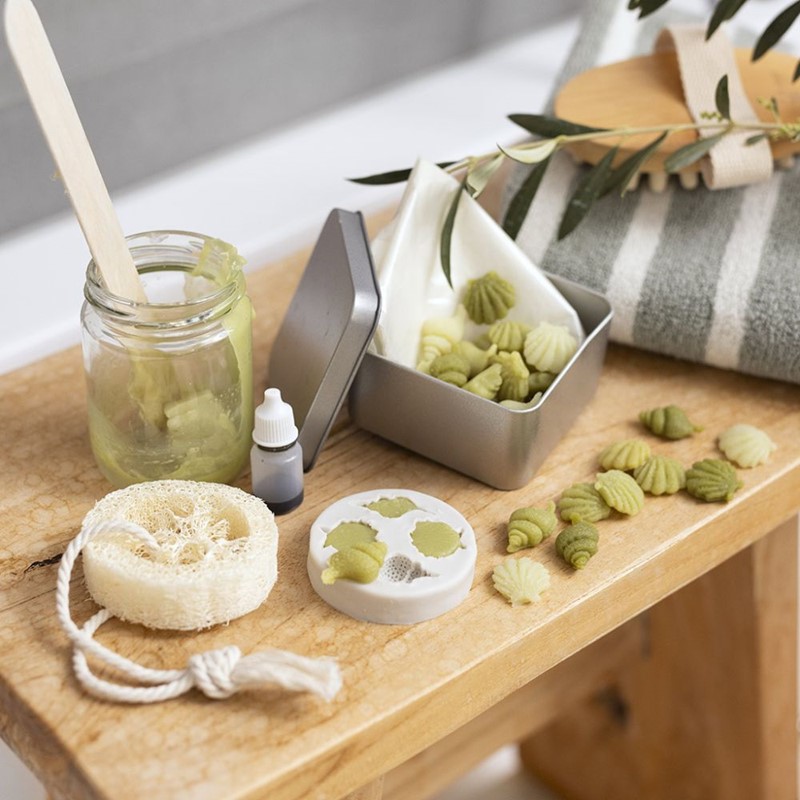 Reisverpakking met kleine olijfoliezeepjes en loofahspons