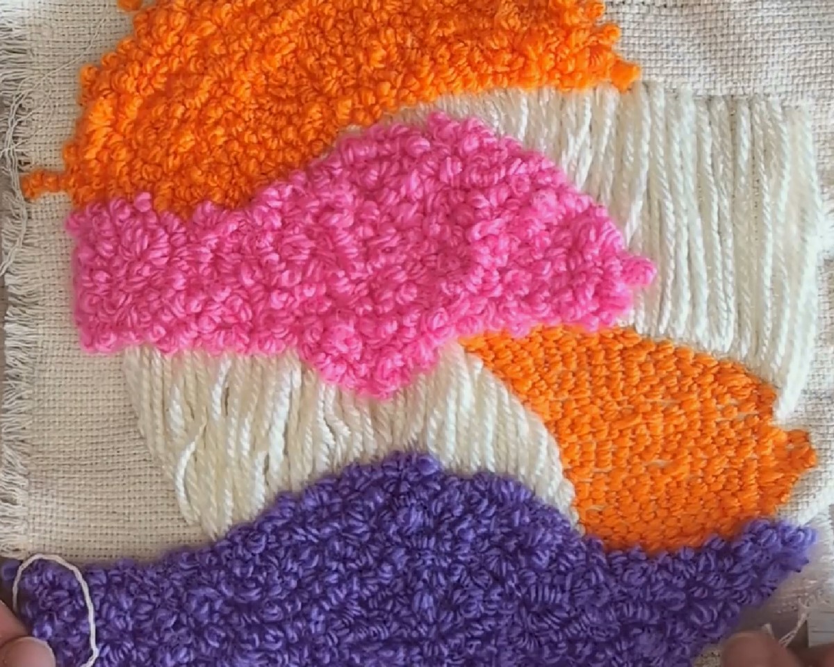 Punch needle met acrylgaren voor een abstract borduursel