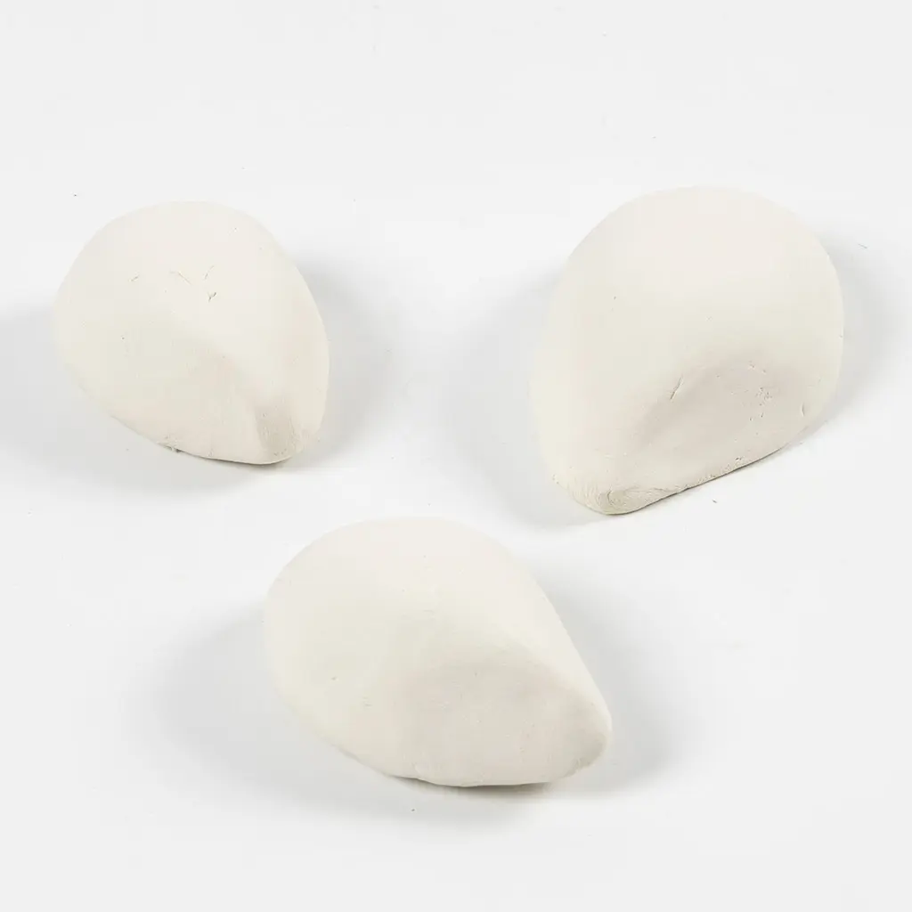 Drie druppelvormige lichamen van witte boetseerklei op een egale witte achtergrond.