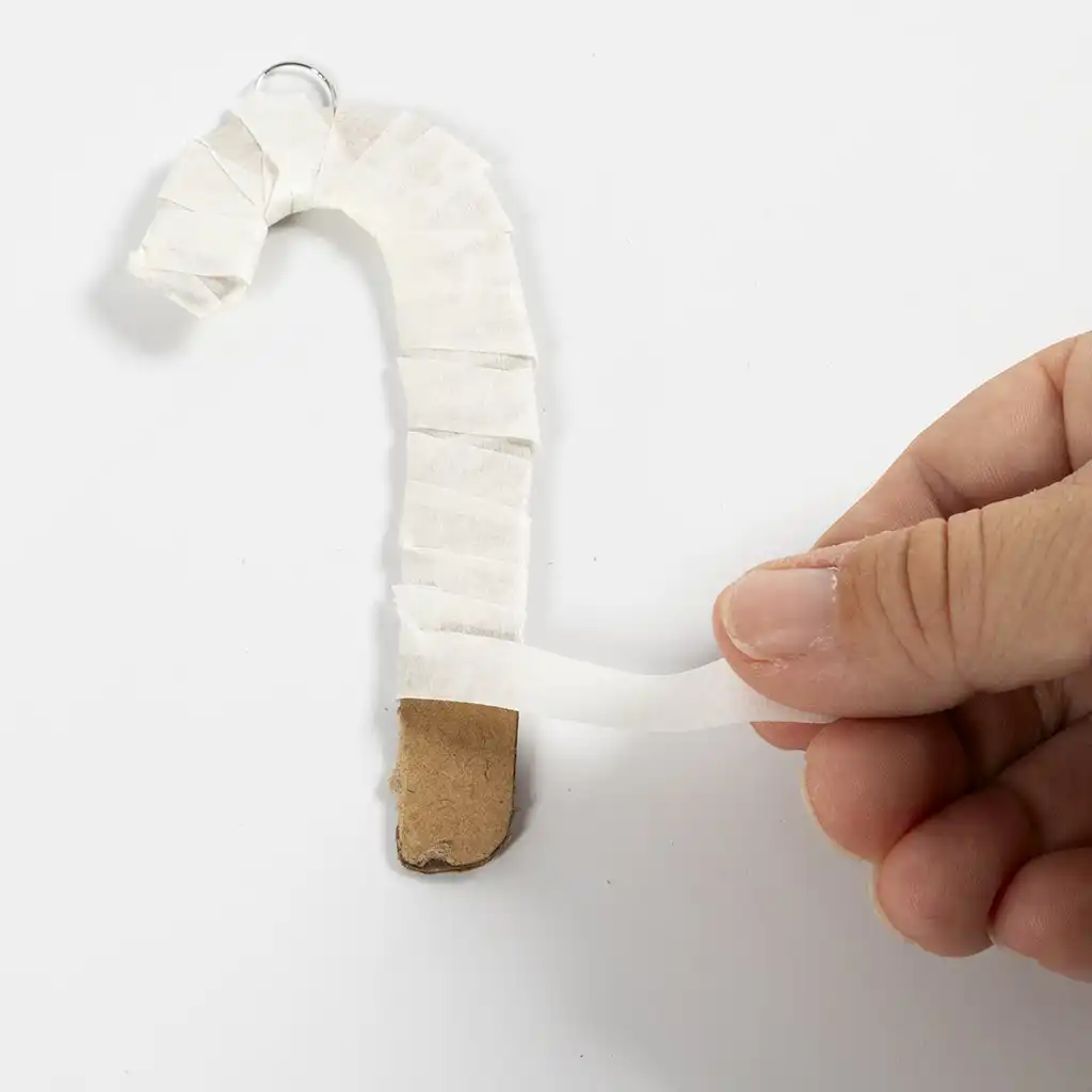 De kartonnen zuurstok wordt van boven naar beneden strak omwikkeld met een smalle strook witte schilderstape.