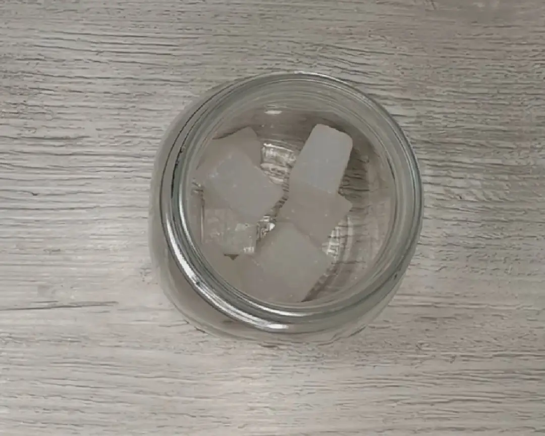 blokjes transparante zeep in een glazen beker