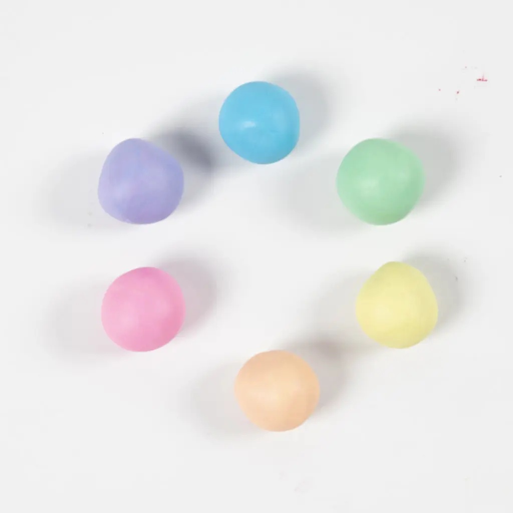 Zes pastelkleurige bolletjes klei gerangschikt in een cirkel.