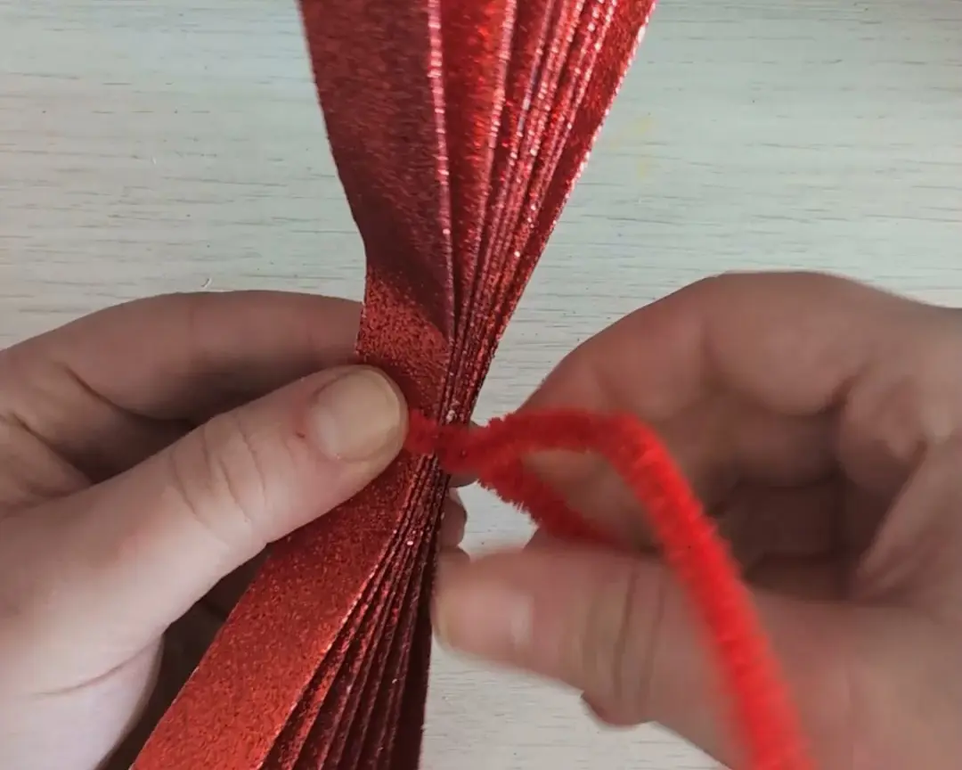 rood glitterpapier met chenilledraad erom gedraaid