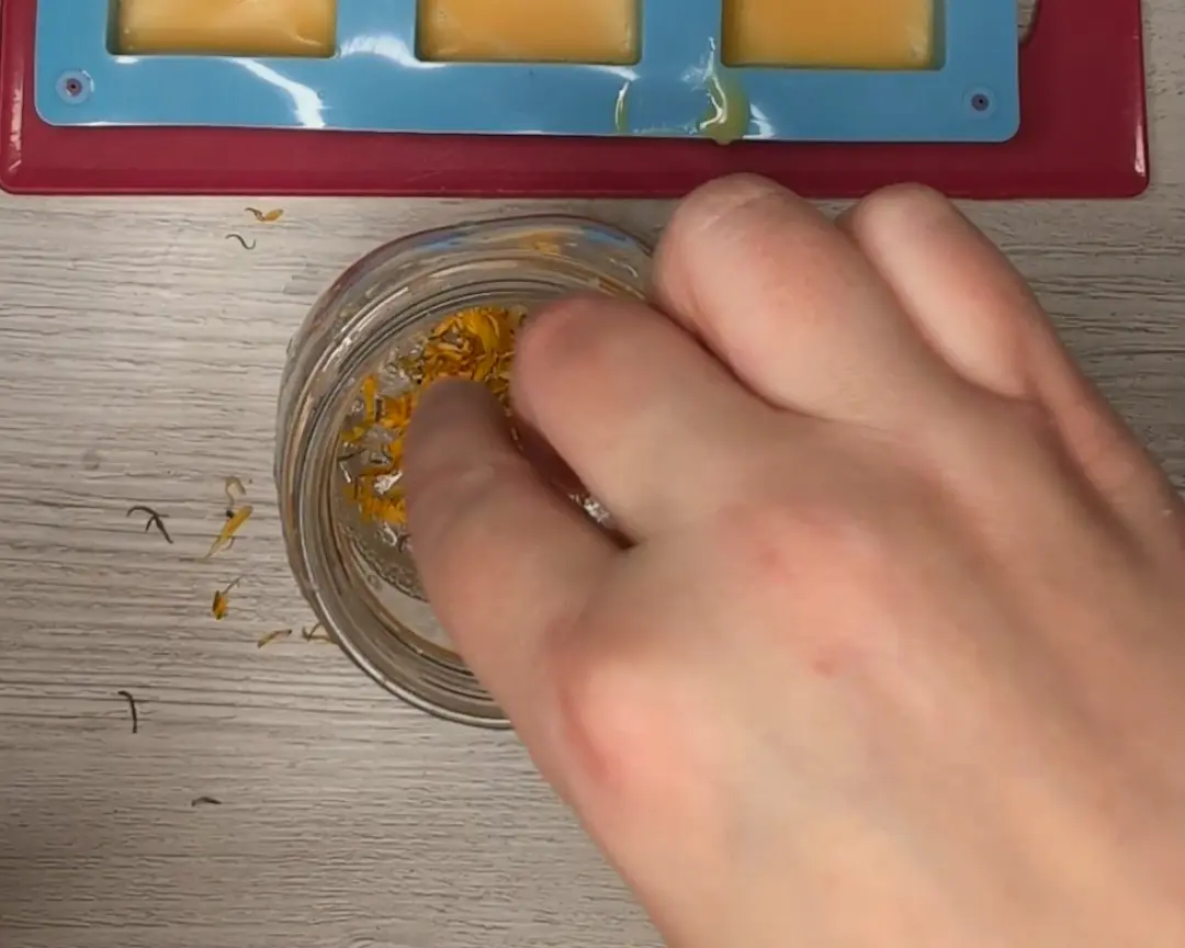 gedroogde calendula wordt in vloeibare transparante zeep gemengd.