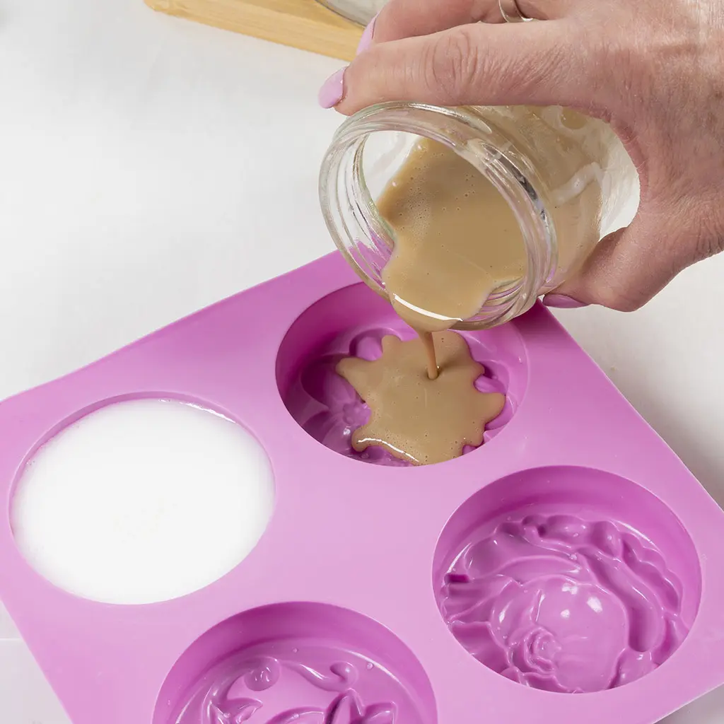 1 glazen pot met bruine zeep worden in een rsiliconen mal gegoten. 4 cirkels met bloemen patronen