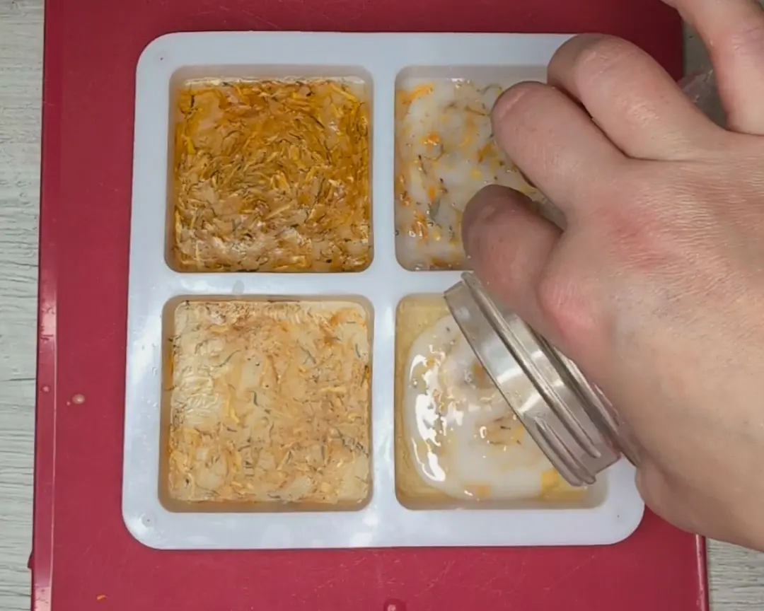 witte vloeibare zeep gemengd met calendula wordt in de mal gegoten