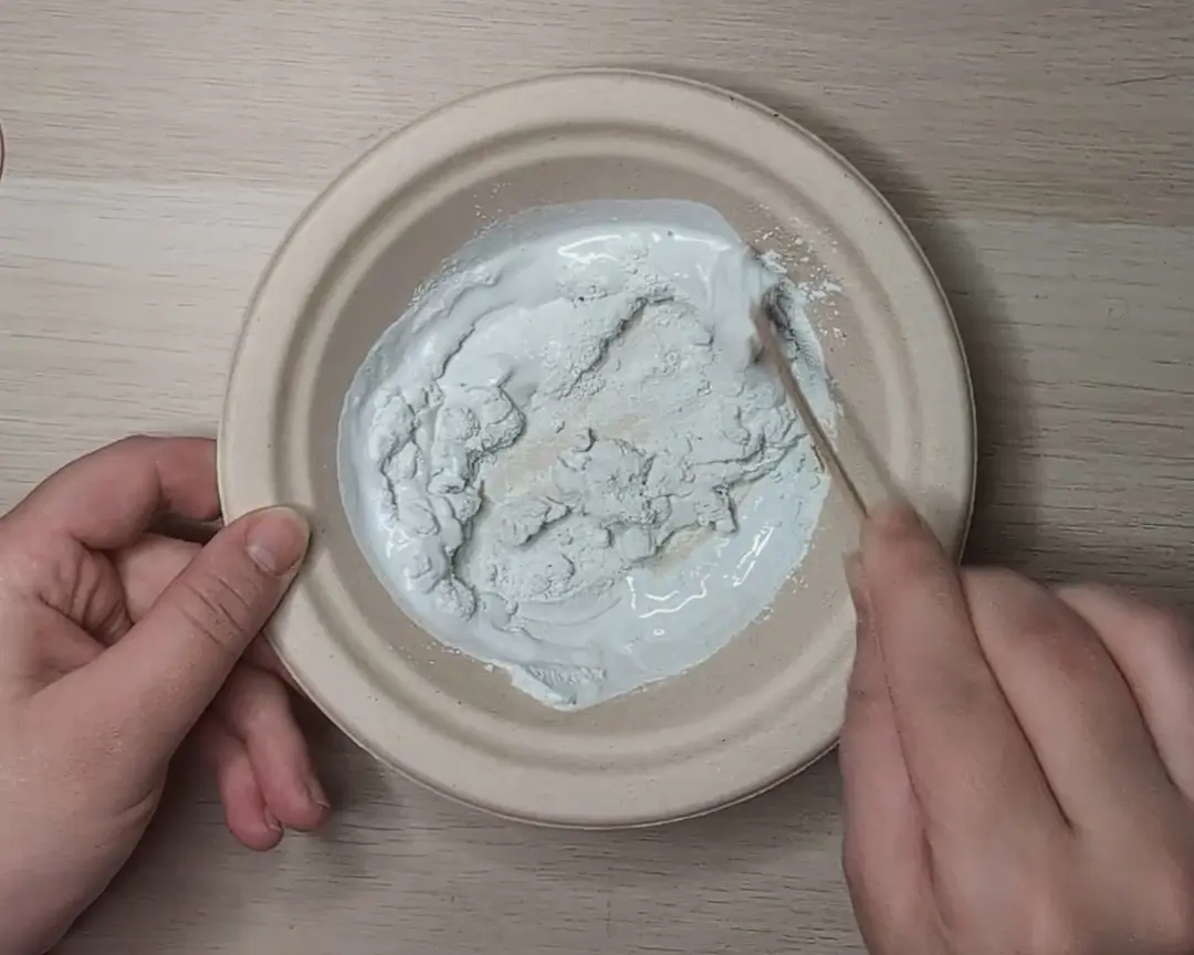 voegsel en water worden in een mengbakje gemixt.