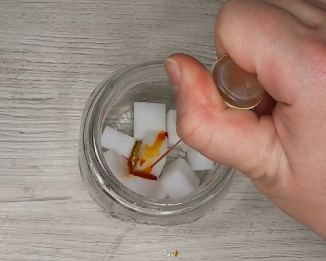 blokjes zeep in een glazen pot met gele kleurstof