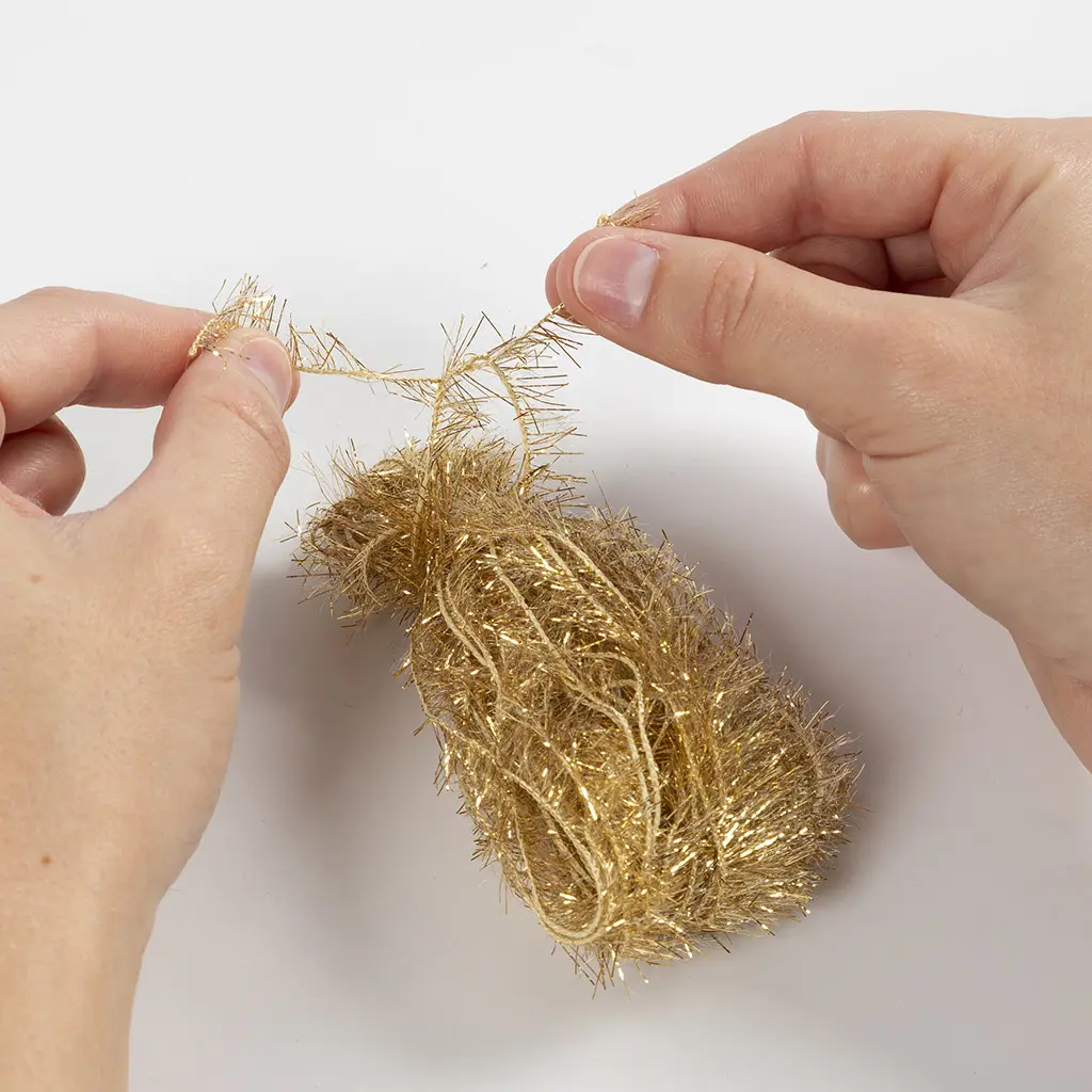 Het gouden kwastje wordt bovenaan extra stevig vastgeknoopt met een draadje.