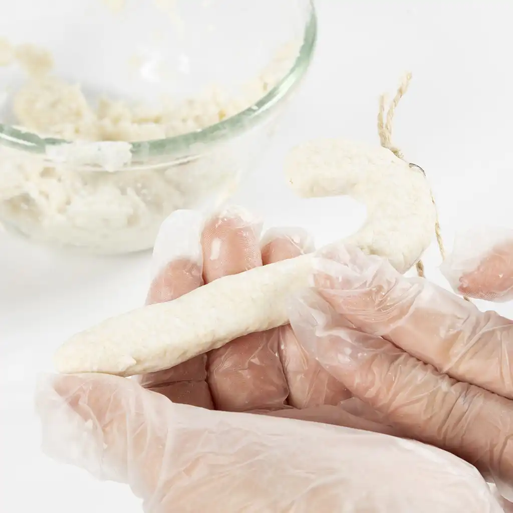 De zuurstok wordt zorgvuldig gladgestreken en volledig bedekt met de witte papierpulp.