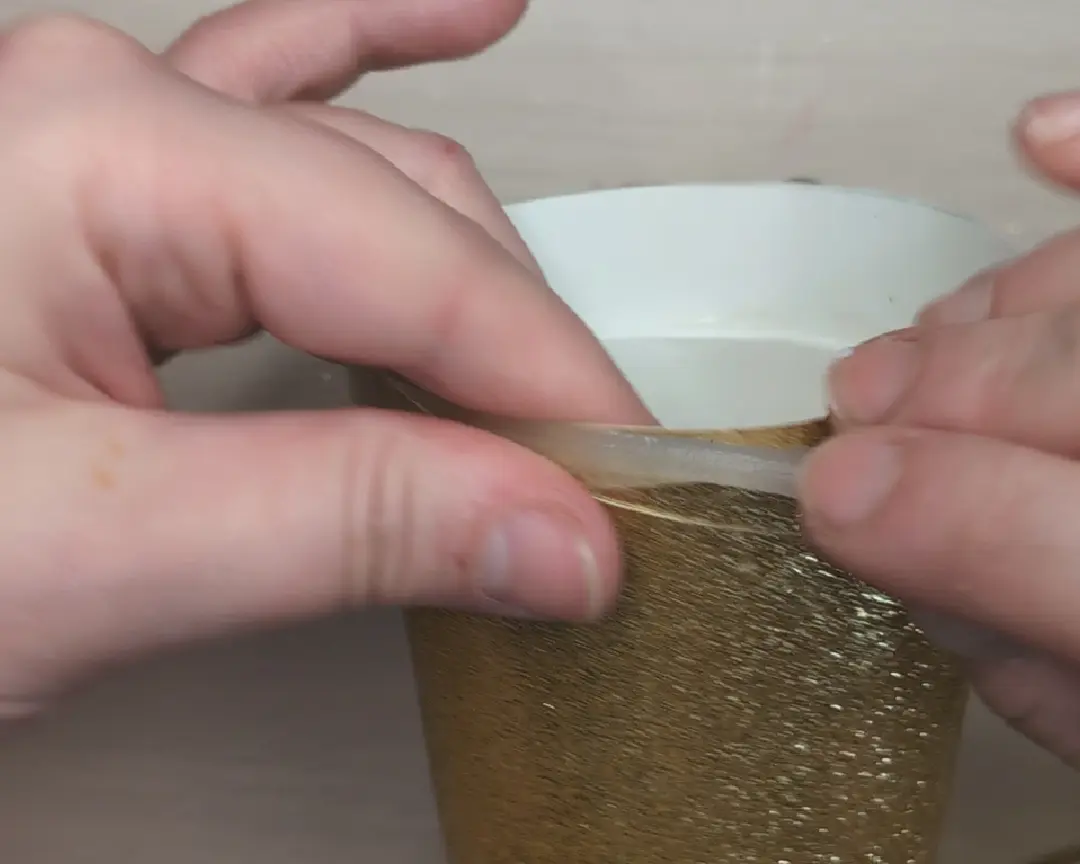 sticky clay op de rand van de koker geplakt.