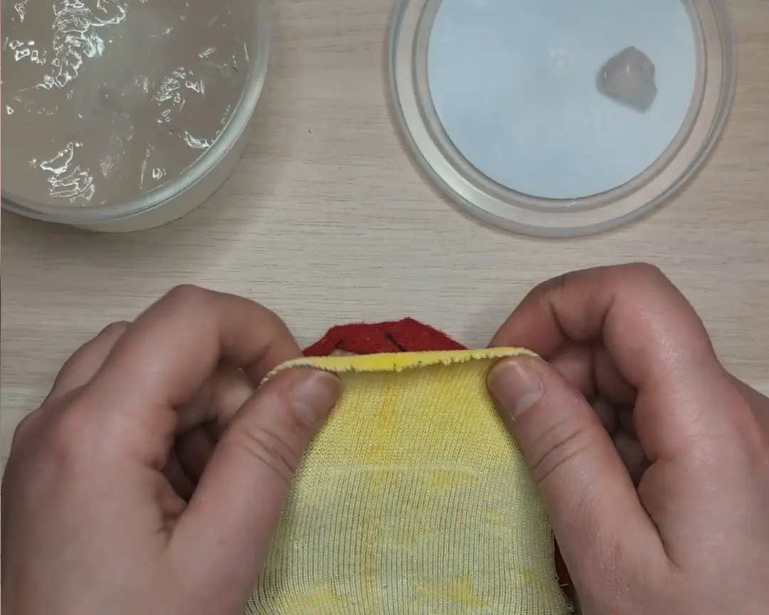 chenille draad wordt langs de rand van de sok en vilt gelijmd.