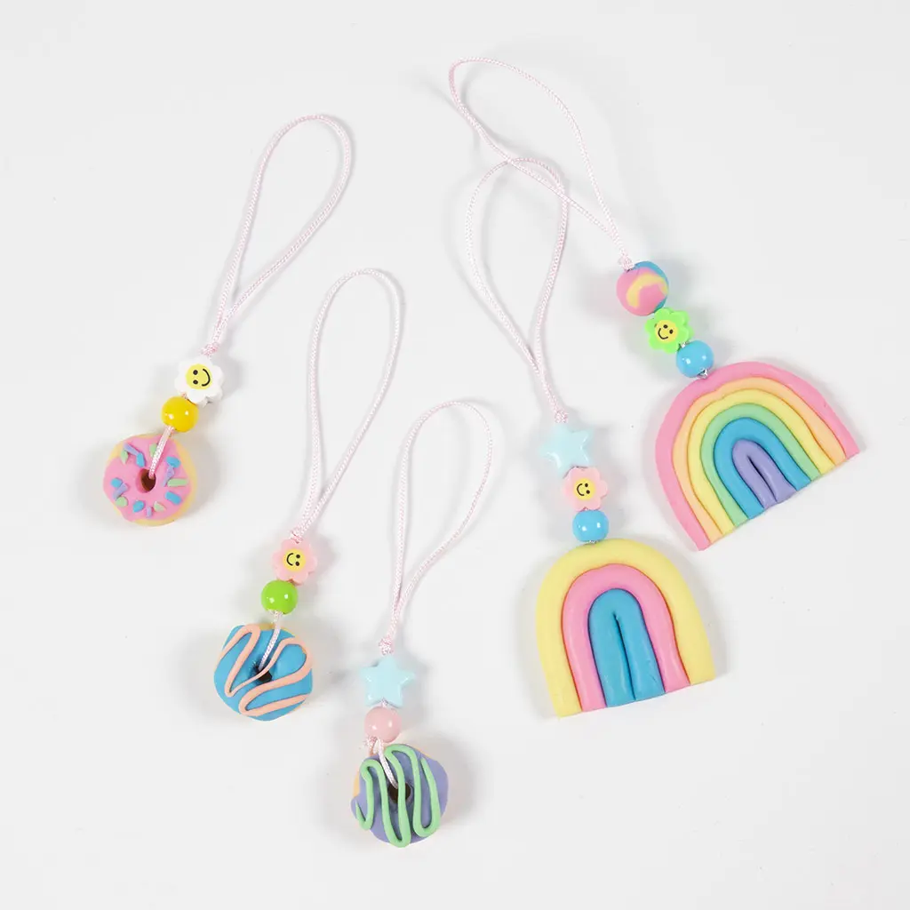 Vijf kleurrijke telefoonbedels gemaakt van kleidonuts, regenboogjes en vrolijke kraaltjes.