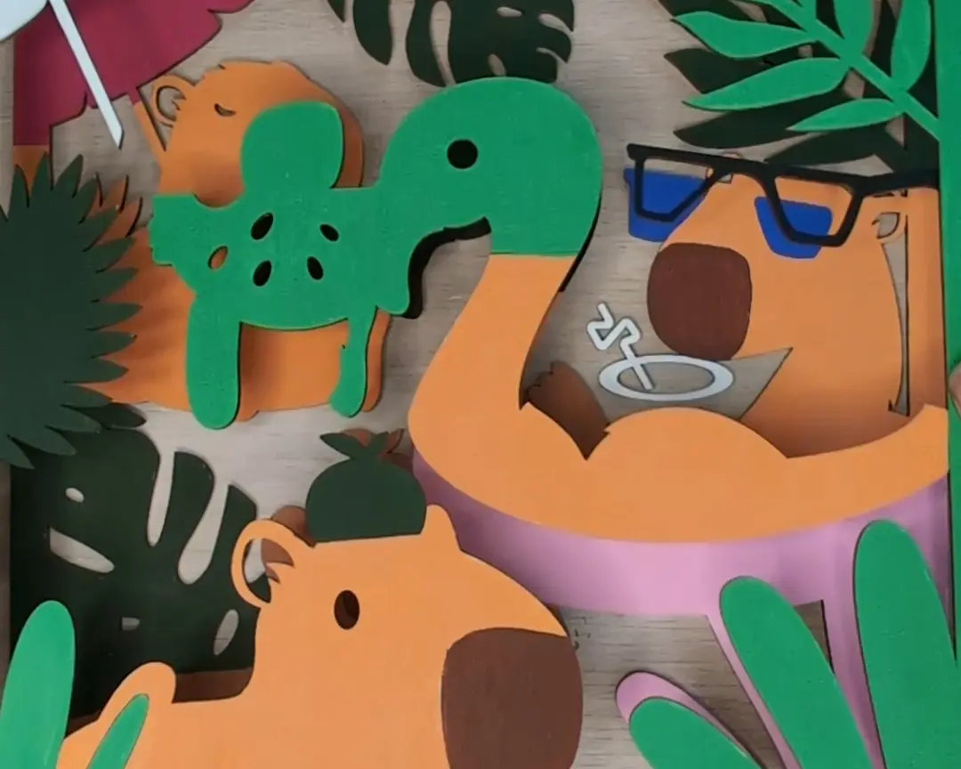 Detailopname van de geassembleerde ingekleurde lagen met een groene capybara-figuur, een capybara met zonnebril en roze flamingo zwemband, omgeven door donkergroene bladeren.
