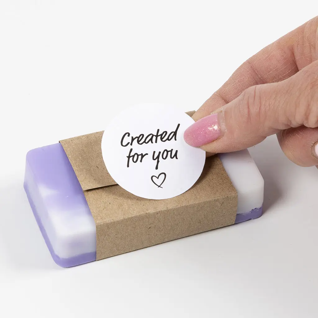 ronde sticker wordt op het kartonnen hoes geplakt waar de zeep inzit