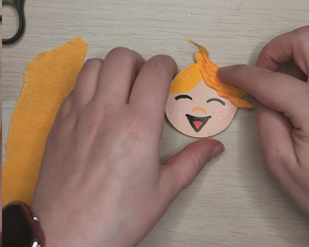 crêpeppapier wordt op het gezichtje geplakt.