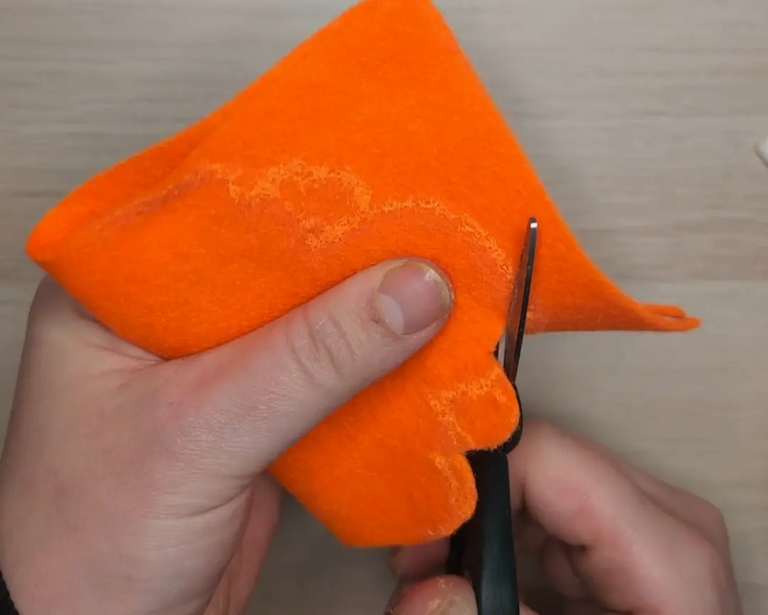 oranje vilt wordt in een wolkenpatroon uitgeknipt.