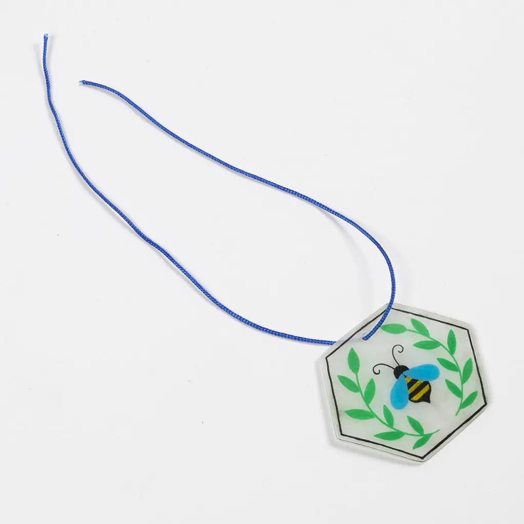 Een dun blauw koord is door het geponste gaatje van de zeshoekige krimpfolie-hanger met de bij heen geregen.

