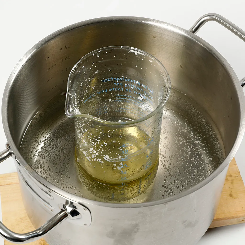 glazen kan wordt verwarmd in een pan met water