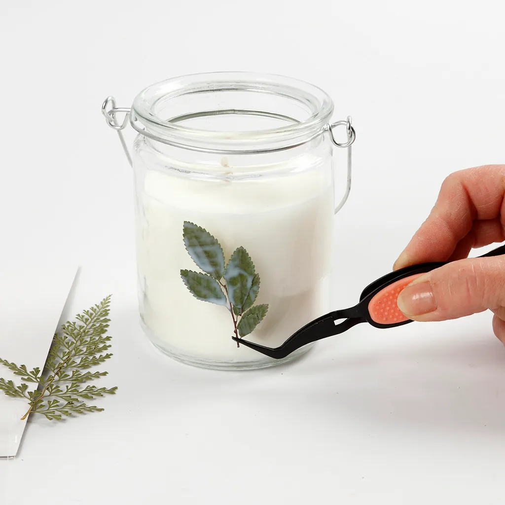 pincet wordt gebruikt om de blaadjes op de glazen pot te bevestigen