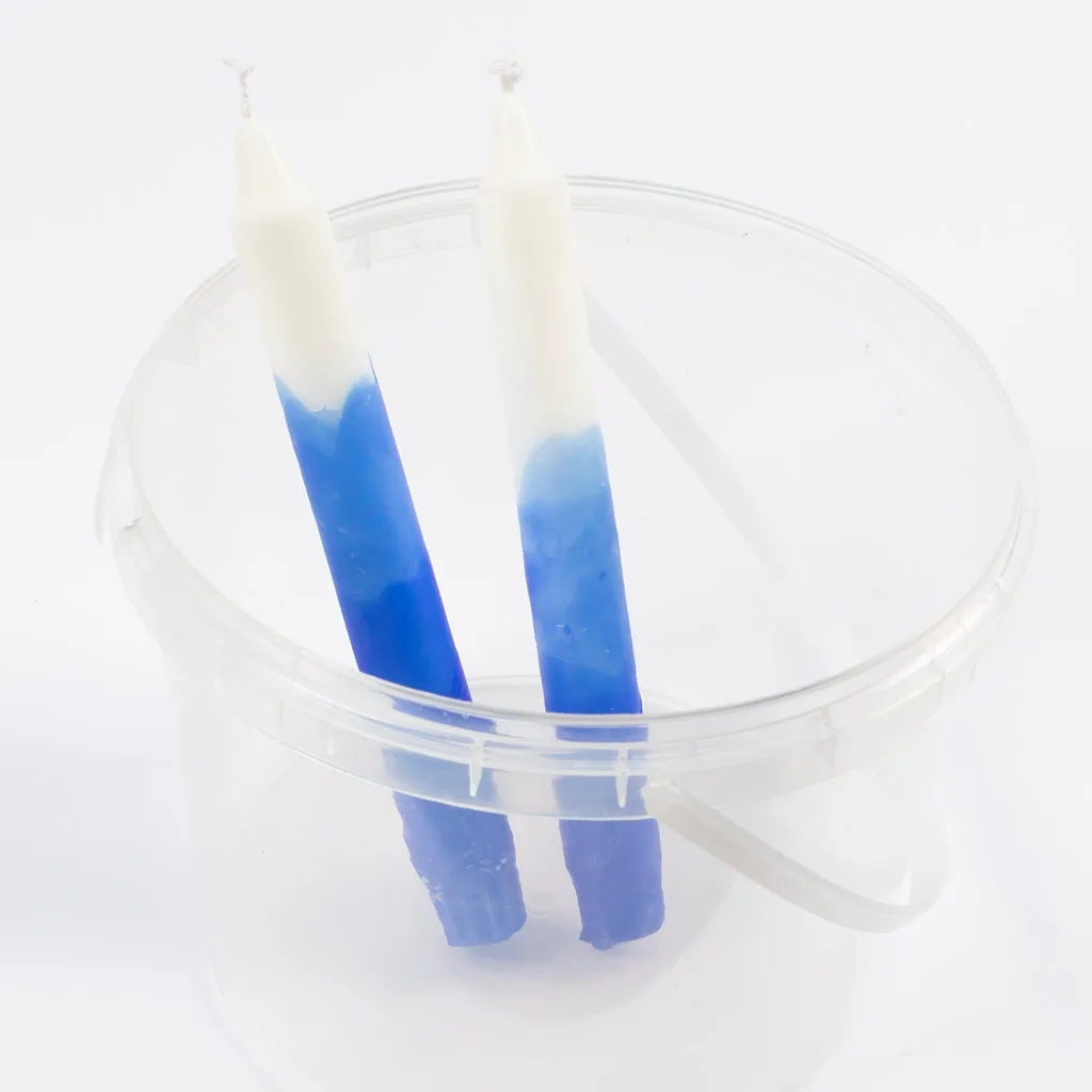 twee gekleurde kaarsen drogen rechtop in een plastic emmer