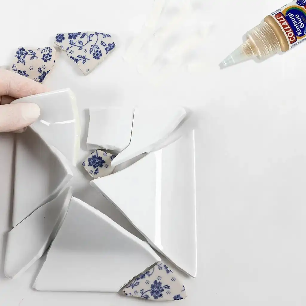 kapotte delen worden beet gehouden met een hand en de fles kintsugi lijm